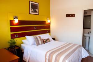 阿雷基帕卡萨代阿维拉住宿加早餐旅馆的卧室配有白色的床和黄色的墙壁