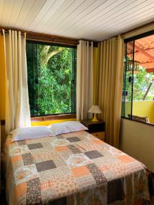 安格拉杜斯雷斯Casa Martureza的一间卧室设有一张床和一个大窗户