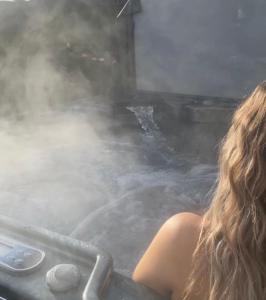 Wee Hoose-Private-Hottub -Romantic Break-Portaferry的坐在充满蒸汽的浴缸中的女人