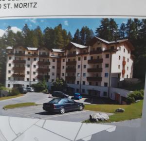圣莫里茨St. Moritz的停在大楼前停车场的汽车