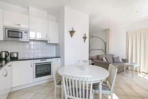 凡尔赛曼德马塞尔公寓的厨房以及带白色桌椅的起居室。