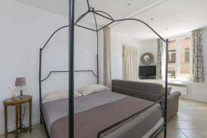 凡尔赛曼德马塞尔公寓的一间卧室配有一张天蓬床和一台电视机