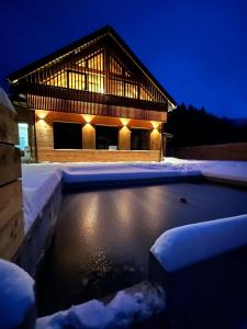 卢捷拿纳德德斯努VagusBouda / Hogo&的夜晚在雪地里放着池塘的房子
