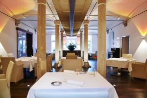 代德斯海姆凯特绍尔霍夫酒店的餐厅设有白色的桌椅和柱子
