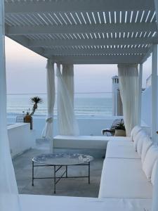 艾西拉Asilah * Dar Badiaa * Riad vue sur l’Atlantique的客厅配有白色家具,享有海景。