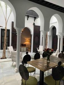艾西拉Asilah * Dar Badiaa * Riad vue sur l’Atlantique的一个带木桌和椅子的庭院和一间房间
