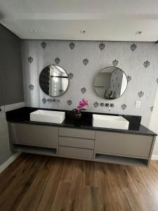 巴拉奈里奥-坎布里乌Belo apartamento reformado próximo a roda gigante的浴室设有2个水槽和2面镜子