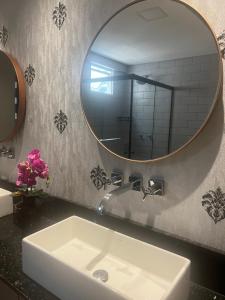 巴拉奈里奥-坎布里乌Belo apartamento reformado próximo a roda gigante的一间带水槽和镜子的浴室