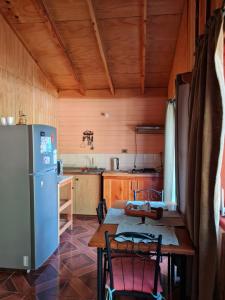 普孔Cabanas El Cipres的厨房配有桌子和冰箱