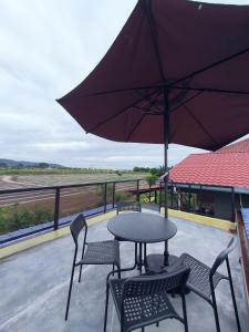 莎阿南Cabin stay with Sunrise and plane spotting view的庭院配有桌椅和遮阳伞。