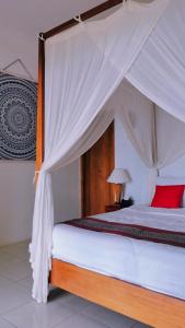 卡里蒙贾瓦米拉贝尔杰芦酒店的一间卧室配有一张带天蓬的床