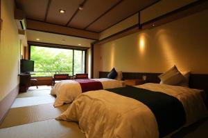 京都Momijiya Honkan Takaosansou的酒店客房设有两张床和电视。