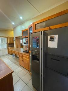 威廉王城Repose Guest house!的厨房配有不锈钢冰箱和木制橱柜