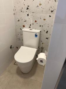 珀斯Parkline Apartments Perth的浴室设有白色卫生间和岩石墙