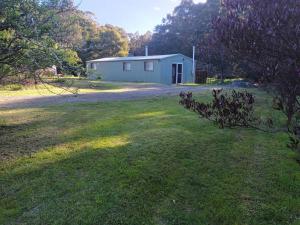 亚瑟港The Shed at Port Arthur. Hidden Gem.的一座有院子的田野上的白色小建筑