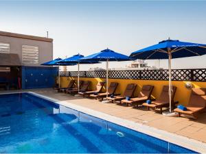 迪拜阿尔巴沙市大商场酒店的一个带躺椅和遮阳伞的游泳池