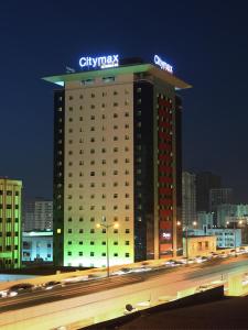 沙迦沙迦城市麦克斯酒店的上面有微弱的协同标志的建筑