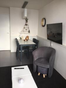 阿沃里亚兹F2 résidence Antarès的一间设有椅子和一张桌子的房间,配有圣诞树