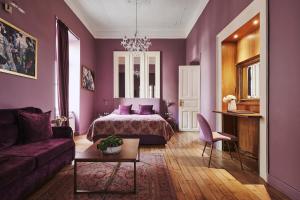 雅典Bohemian Suites Athens的紫色卧室配有一张床和一张沙发