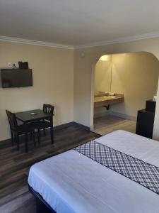 北山Budget Inn的客房设有两张床、一张桌子和一张书桌。