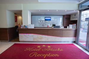 维也纳Hotel Attaché contactless的一间设有前台和红色地毯的餐厅