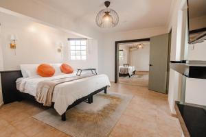棕榈滩Villa Fontana 1 & 2的一间卧室配有带橙色枕头的床
