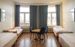 奥斯陆科奇膳食公寓酒店的一间设有两张床和一张桌子及椅子的房间