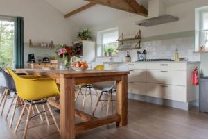 RucphenNatuurhuis Dichtby的厨房配有木桌和黄色椅子