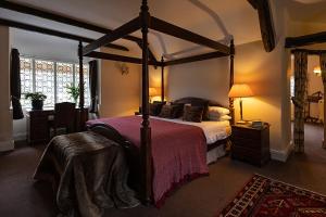 WinsfordThe Royal Oak Exmoor的一间卧室配有一张天蓬床和一张桌子