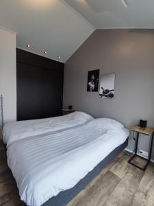 坎彭Chalet IJssel Eilanden Kampen Waterfront Airco的卧室配有一张白色的床和黑色的墙壁