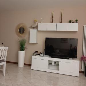 萨罗Appartamento GIRASOLE, Salò的客厅设有大型白色娱乐中心,配有电视