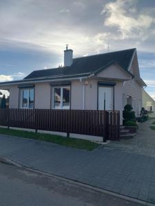 卡梅拉瓦Cozy apartment in Karmelava的前面有栅栏的白色房子