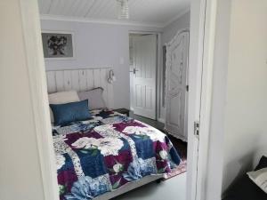 海德堡Rose Cottage AtTheDairyShed的一间卧室配有床,床上装有被子