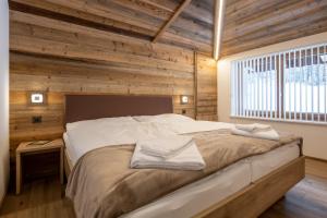 萨斯阿尔马格尔Apartments Alpenrose的一间卧室配有一张带木墙的大床