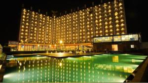 苏拉特Weekend address homestay by shan的一座大型建筑,晚上设有游泳池