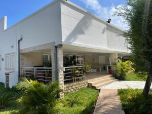 BelasCasa Luxuosa na Ilha do Mussulo的白色的房子,设有门廊和楼梯