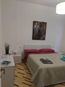 米兰Art Home Apartment Navigli的卧室配有一张床,墙上挂有绘画作品