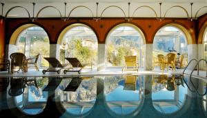 Vols am SchlernHotel Rose Wenzer的客房设有游泳池、椅子和窗户。