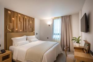 海若克利欧Dimargio Luxury Hotel & Spa的酒店客房设有一张白色大床和一台电视。
