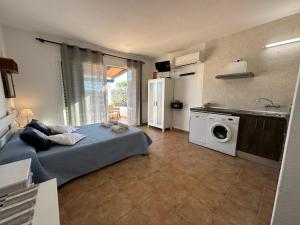 米乔尔海滩Estudi Es Carnatge的一间卧室配有一张床,厨房配有洗衣机