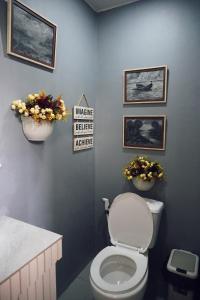 宿务Cebu Backpackers Hostel的浴室配有卫生间,墙上挂有鲜花