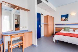 里米尼依赛德凯达酒店的一间卧室配有一张床和一张书桌