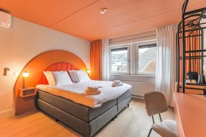 格罗宁根Hotel Halbert的酒店客房,配有一张橙色墙壁的床
