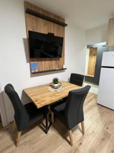 瓦列沃Apartman Antonovic的厨房配有木桌和黑色椅子