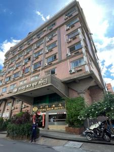 金边Chung Hsin Hotel 中信酒店的一座建筑,前面有一位妇女