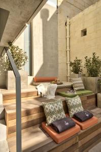 瓦莱塔Casa Ellul - Small Luxury Hotels of the World的户外休息区配有长椅和枕头