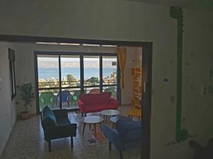 提比里亚turtle guesthouse- tiberias的客厅配有桌椅和窗户