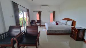 苏梅岛PawPaw Resort的酒店客房,配有一张床和两把椅子