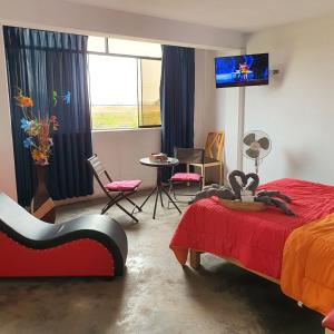 利马Lima Airport Hostel with FREE AIRPORT PICK UP的一间卧室配有一张床、一台电视和一张桌子