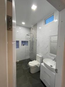 洛坤府JB Grand Resort的浴室配有卫生间、盥洗盆和淋浴。